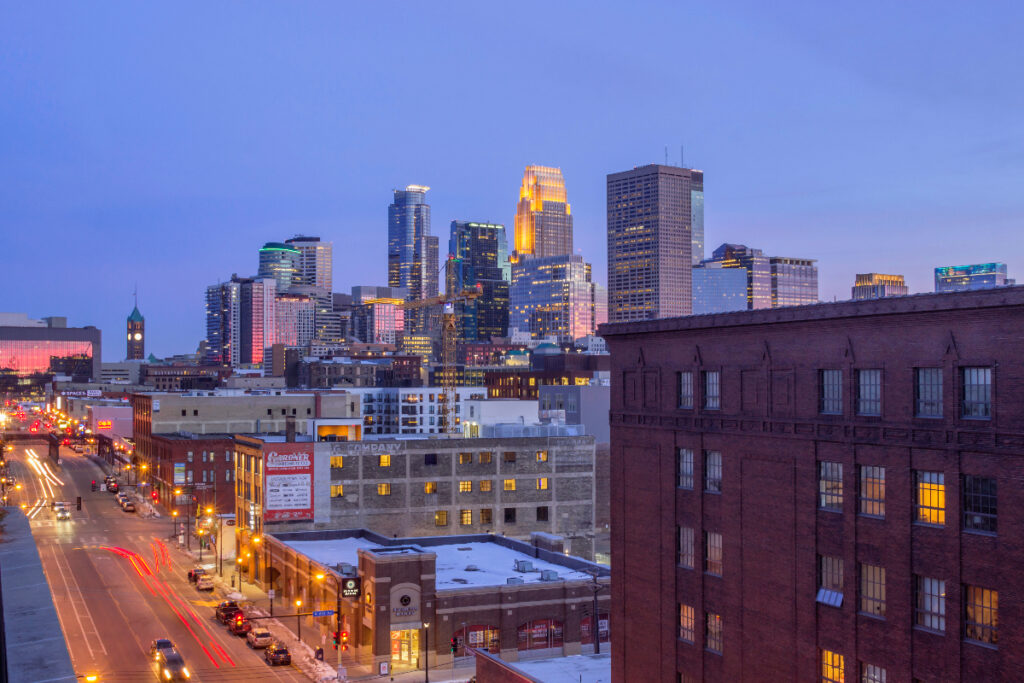 MINNEAPOLIS, MN - MARCH 2018 - A Wide Angle Shot of Downtown Minneapolis Reflecting Pink Dusk Light as North Loop Traffic Passes in the Foreground