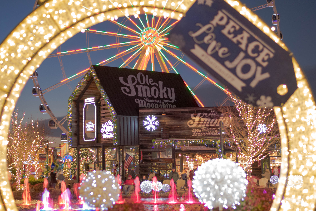 Gatlinburg, Tennessee/USA - December 23, 2018: Christmas time at The Island at Dollywood in Pigeon Forge with the Ferris wheel lit up in the background behind the Ole Smoky Tennessee Moonshine store.